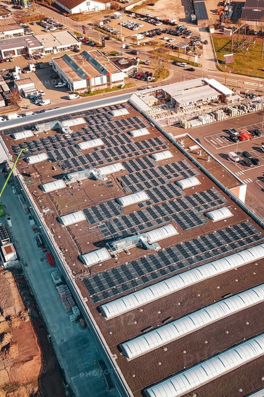Industrial building with numerous solar panels on the roof in an urban environment, PV Bau Auf OBI Bau Markt, Mühlacker, Enzkreis, Germany