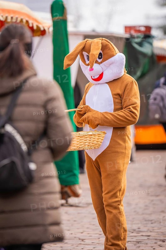 Person wearing rabbit costume interacts with others at a busy market, Easter campaign, Sindelfingen, Böblingen district, Germany