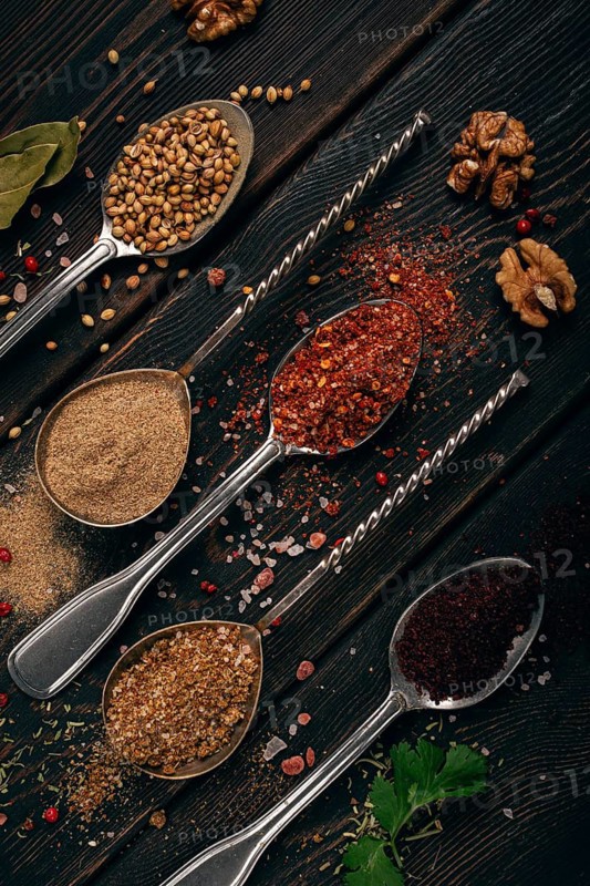 Georgian spices in spoons, on a wooden background, top view, no people