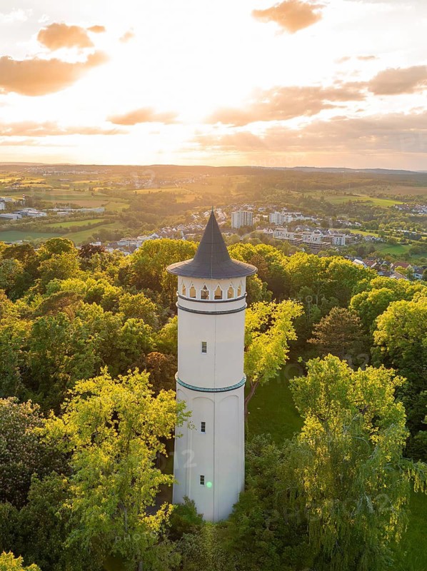 An elegant tower in the evening sunlight, surrounded by lush green forest, Engelberg Tower, Leonberg, Germany