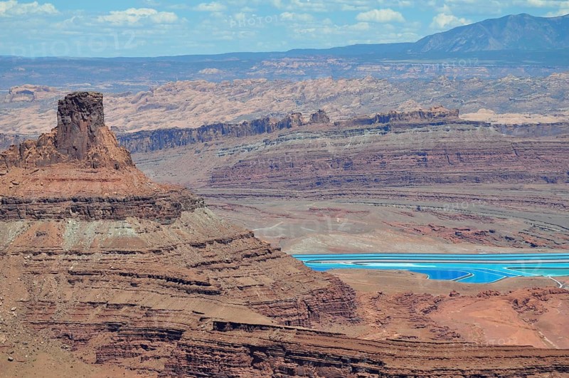 Sublime rock in the foreground of a canyon landscape with turquoise salt pools, Dead Horse State Park, Moab, Utah, USA