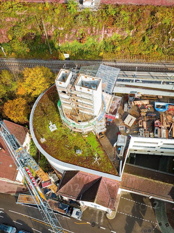 Aerial view of a construction site with concrete tower, construction site material and surrounding roads, extension of the ZOB Calw tower onto the new track of the Hermann Hesse railway, Calw, Black Forest, Germany
