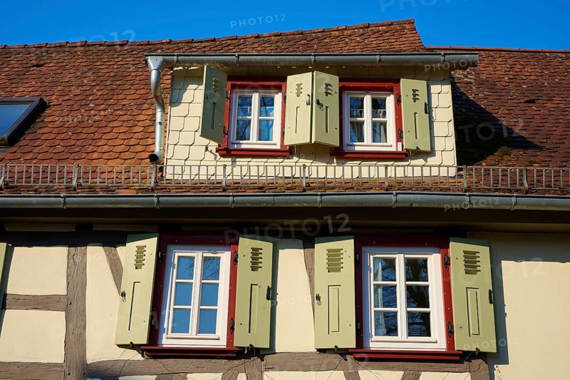 A traditional half-timbered house roof with projecting shutters and blue sky in the background, Erbach, Odenwald, Südhessen, Hesse, Germany