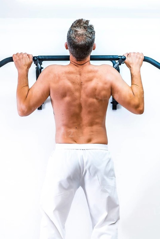 Muscles of the patient doing a pull-up. Reopening with security measures of physiotherapists in the Covid-19 pandemic. Osteopathy, therapeutic chiromassage