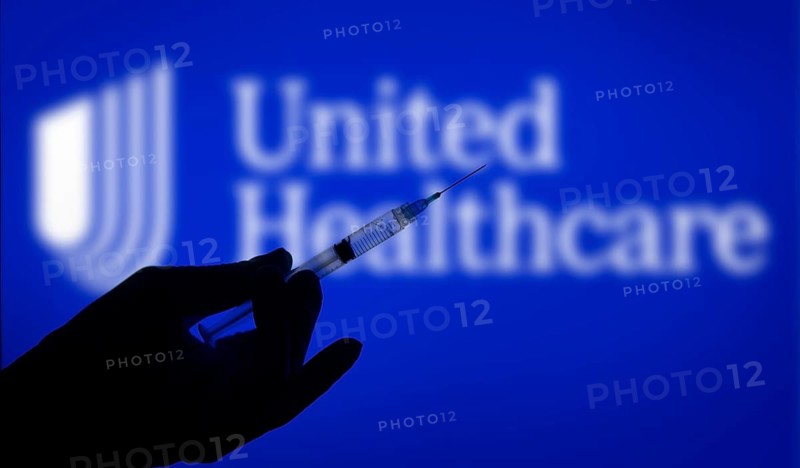 Dhaka, Bangladesh- 06 Dec 2024: A gloved hand holding a syringe in front of the UnitedHealthcare logo. UnitedHealth Group Incorporated is an American multinational health insurance company.