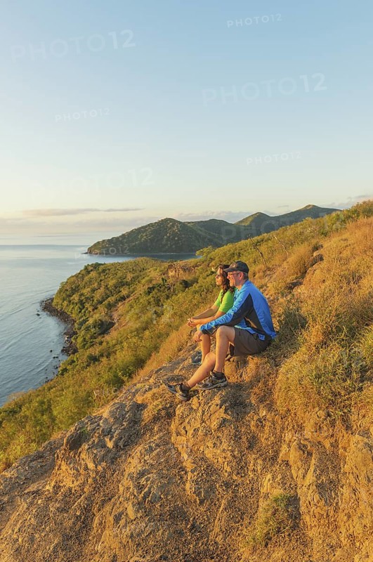Couple watching island view at sunset, Drawaqa Island, Yasawa island group, Fiji