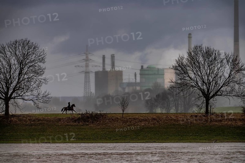 Riders on the banks of the Rhine opposite Krefeld-Uerdingen, in winter, the Krupp-Mannesmann metallurgical plant, HKM in Duisburg-Hüttenheim, coking plant, gas power plant, cooling towers, Rheinauen in Duisburg-Mündelheim, North Rhine-Westphalia, Germany