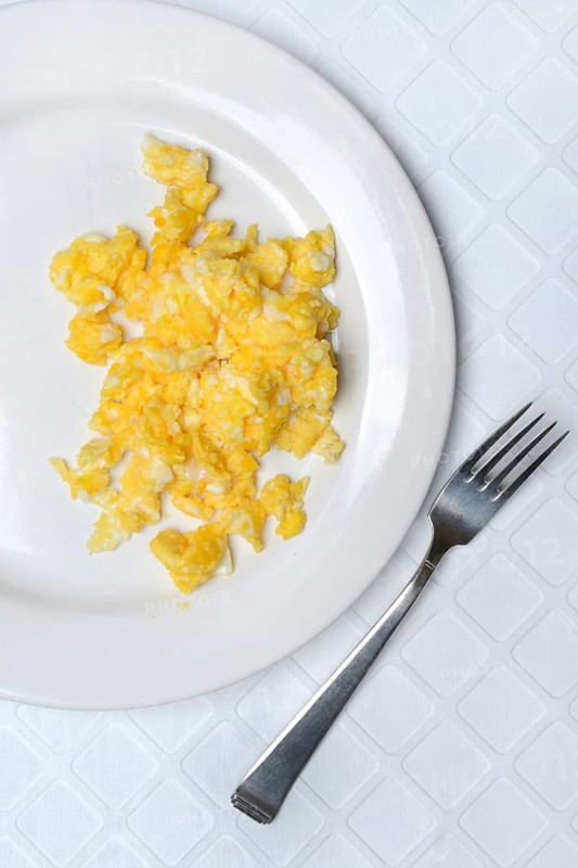 Scrambled eggs on a plate and fork
