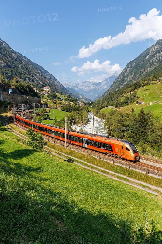 Railway passenger train of the type Stadler Flirt of the Südostbahn on the Gotthard railway in the Alps in Wassen, Switzerland
