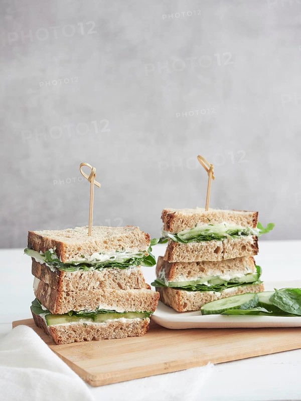 Sandwiches with cucumber and green spinach, stacked and cut in half