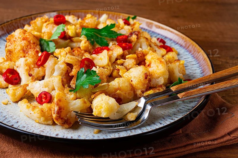 Spicy fried cauliflower served on a wooden countertop