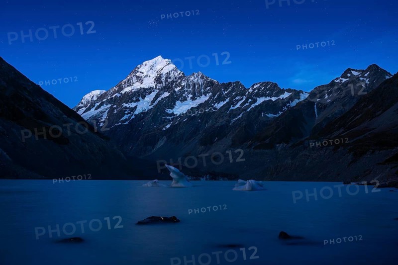 Mountainous landscape. Hooker Lake and Aoraki Mount Cook. Evening atmosphere, blue hour, first stars in the sky. Aoraki Mount Cook National Park, Canterbury, South Island, New Zealand