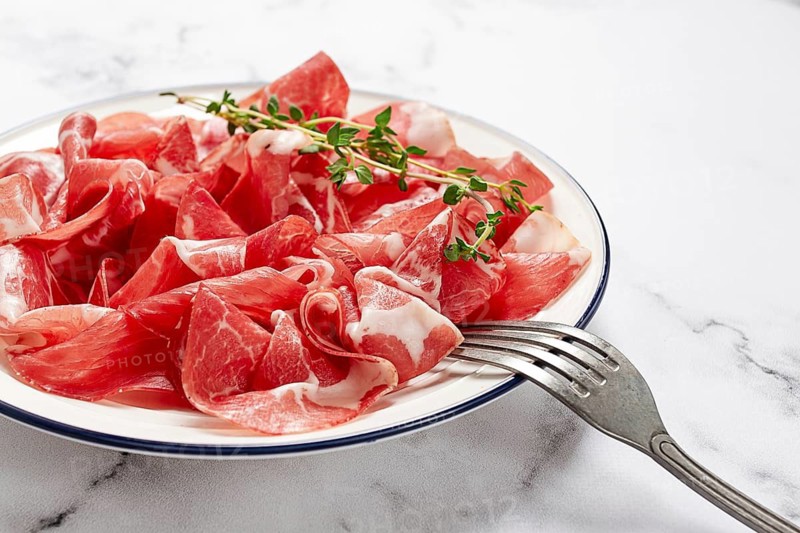 Plate with sliced cured meat, pork neck, prosciutto coppa, Italian delicacy