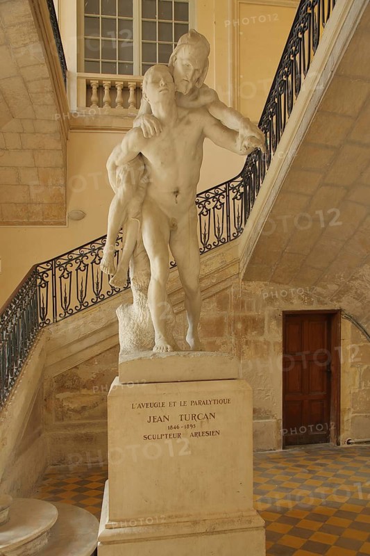 Stone sculpture of the blind and the lame by Jean Turcan, symbol, blind, lame, sick, helping, suffering, two, piggyback, carrying on back, Palais Archevêque, Episcopal Palace, Place de la République, Kaiserplatz, Arles, Bouches-du-Rhône, Camargue, Provence, France
