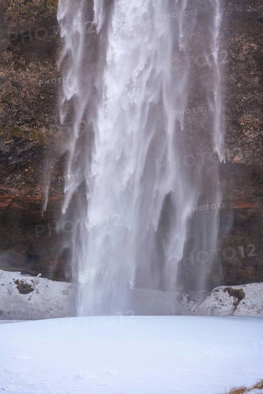 Detail of Seljalandsfoss waterfall with snow in winter in Iceland