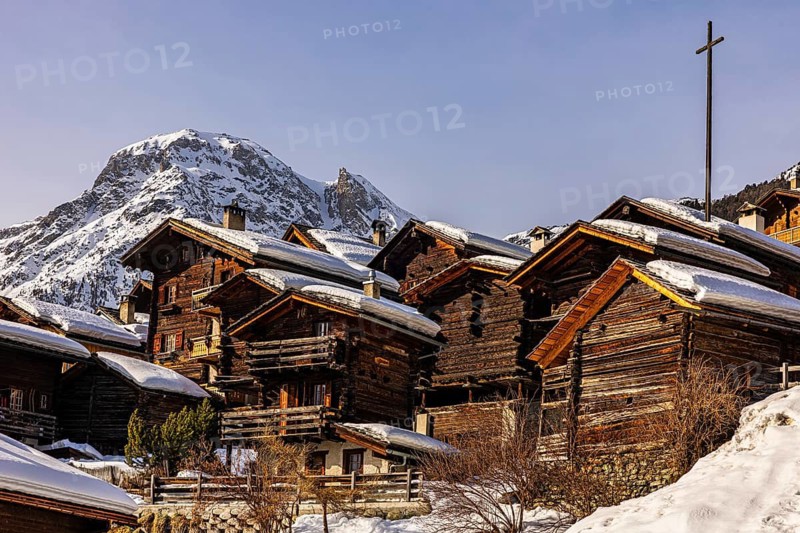 Snow-covered old farmhouses, large wooden cross, historic town center, Grimentz, Val d'Anniviers, Valais Alps, Canton of Valais, Switzerland