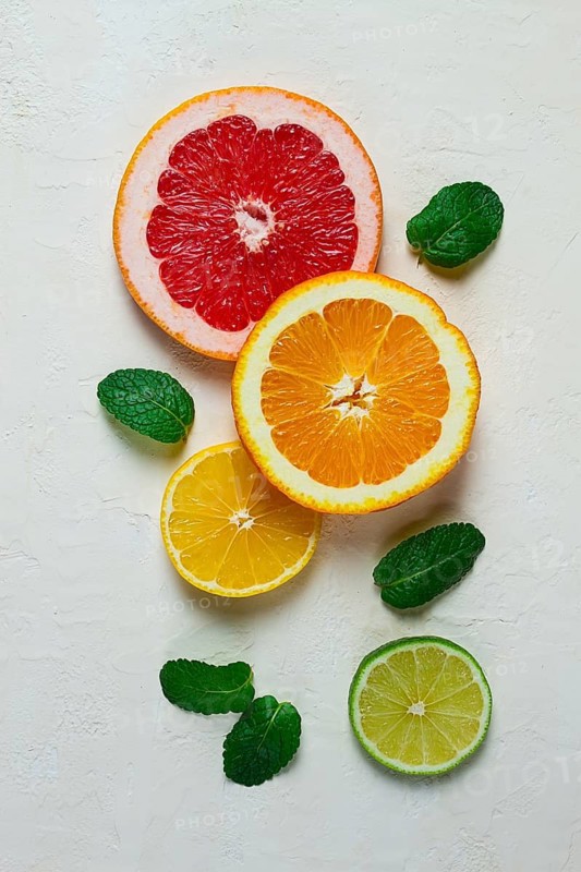 Food concept, wallpaper, sliced citrus fruits, top view, on a light table, with mint leaves, food background