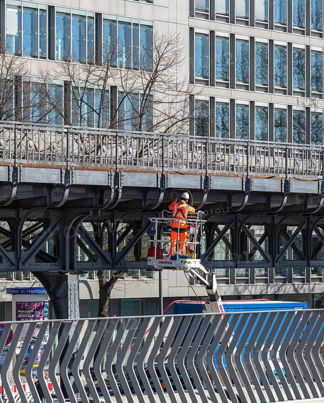 Construction worker surveying the elevated railway along the Elbe promenade, Hamburg, Germany