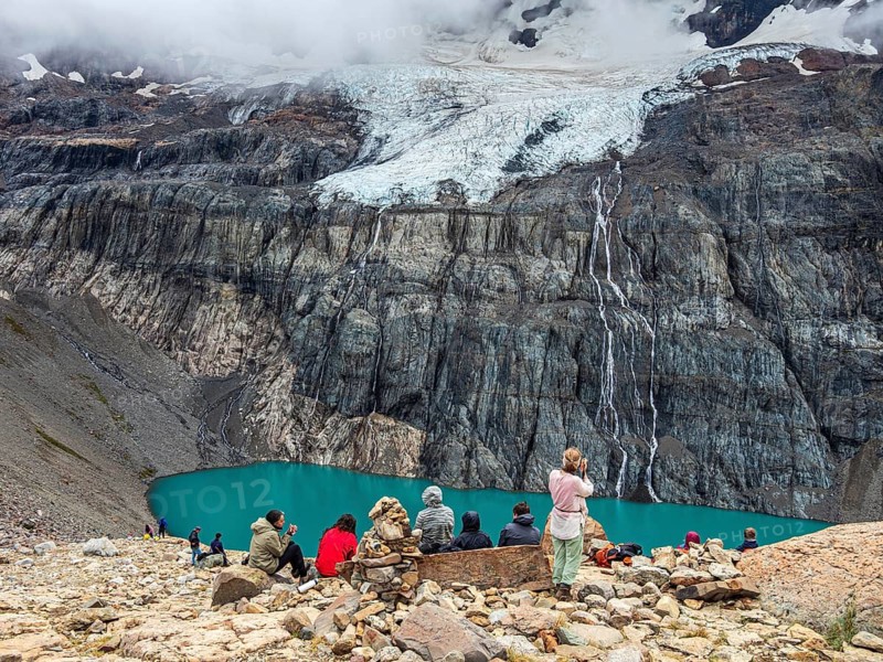 Hikers at the lagoon below mountain Cerro Castillo, glacial streams, nature reserve Cerro Castillo, Aysen, Chile