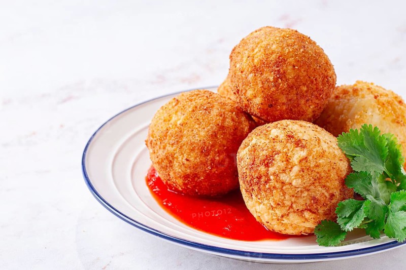 Arancini appetizer with tomato sauce, on a white plate, homemade, no people