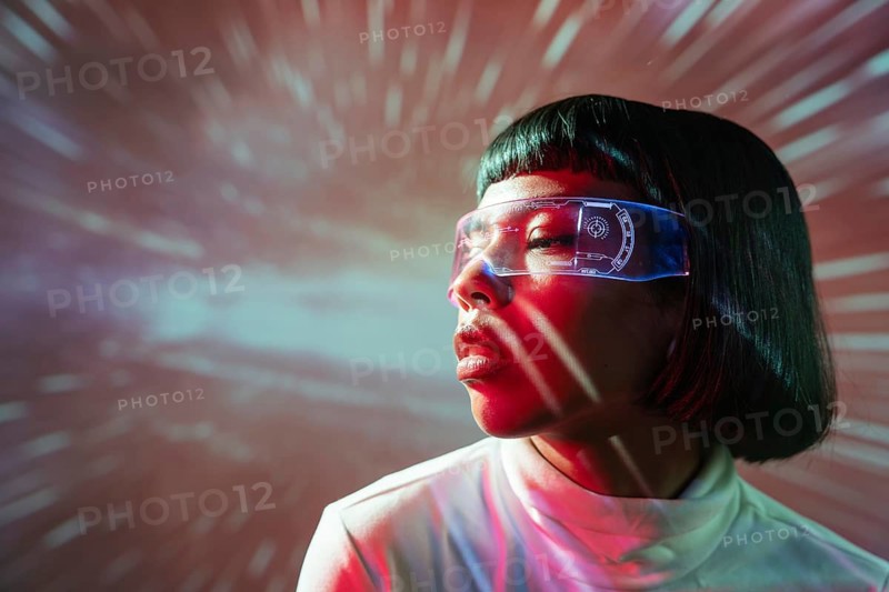 Latin woman immersed in the virtual world, wearing advanced futuristic virtual reality glasses with a dynamic, colorful background showing motion and light effects