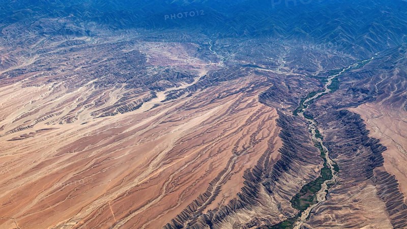 Desert landscape with a winding river and overgrown banks, The landscape and desert near Nasca in the Andes of Peru