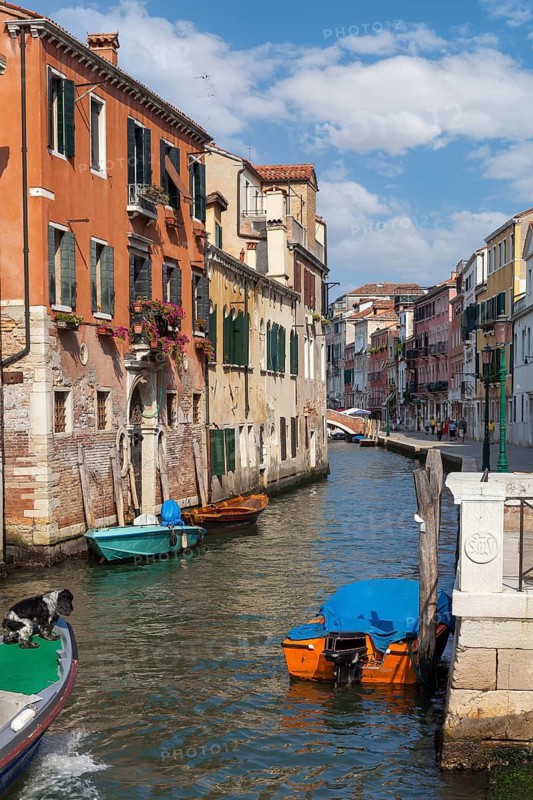 Venetian canal with beautiful old buildings and boats in sunny weather, Venice, Italy