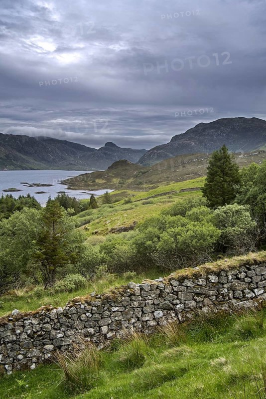Old dry stone wall and Loch Glencoul near Unapool and Gleann Dubh, Kylesku, Sutherland in the Highlands of Scotland, UK