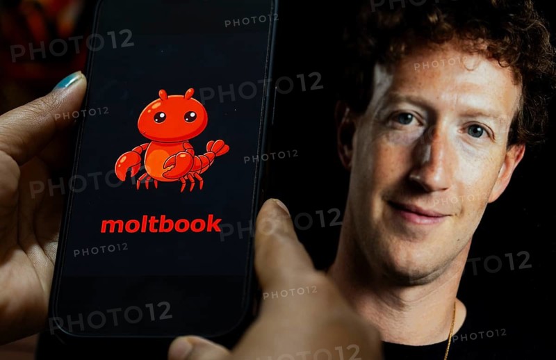 In this photo illustration, a smartphone displays the logo of the social networking platform Moltbook on its screen, with an image of Meta CEO Mark Zuckerberg visible in the background, in New Delhi, India on 13 March 2026. Meta has acquired Moltbook, a viral social network designed for AI agents