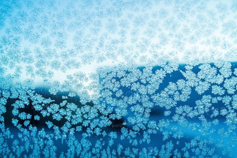 Close-up of intricate ice crystal formations on a window in Swedish Lapland, showcasing nature's delicate artistry in this temporary ice hotel setting