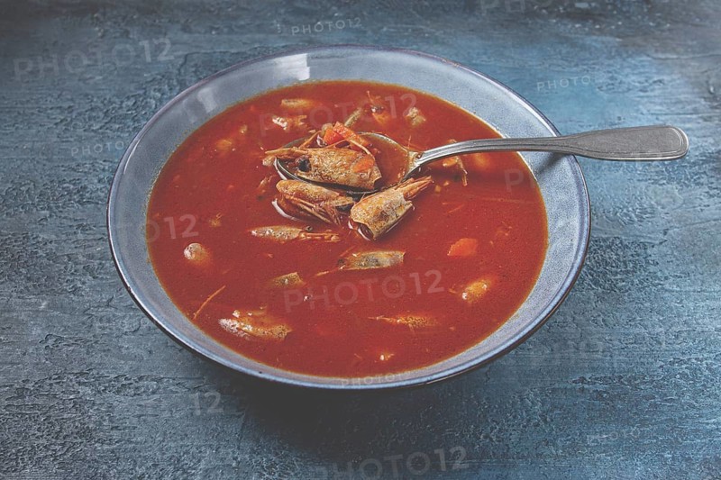 French shrimp bisque soup, in a plate, on a blue background, close-up, no people
