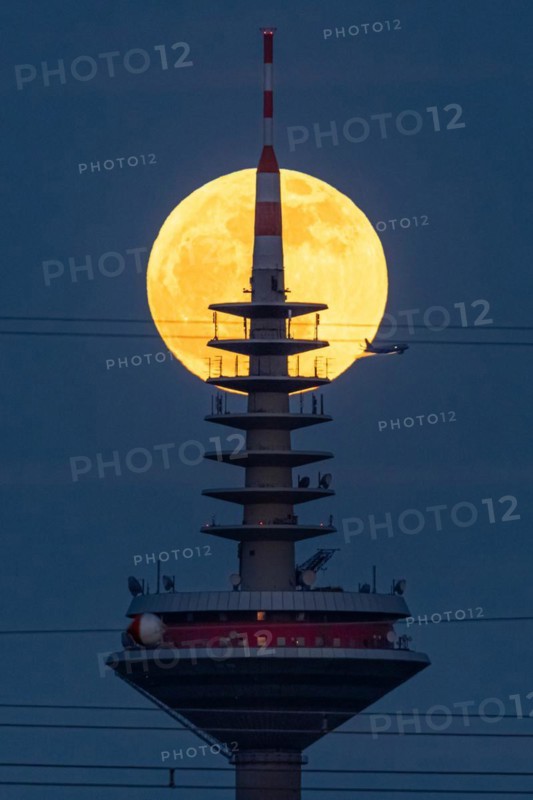 The full moon passes behind the top of the Europaturm in Frankfurt am Main, Frankfurt am Main, Hesse, Germany