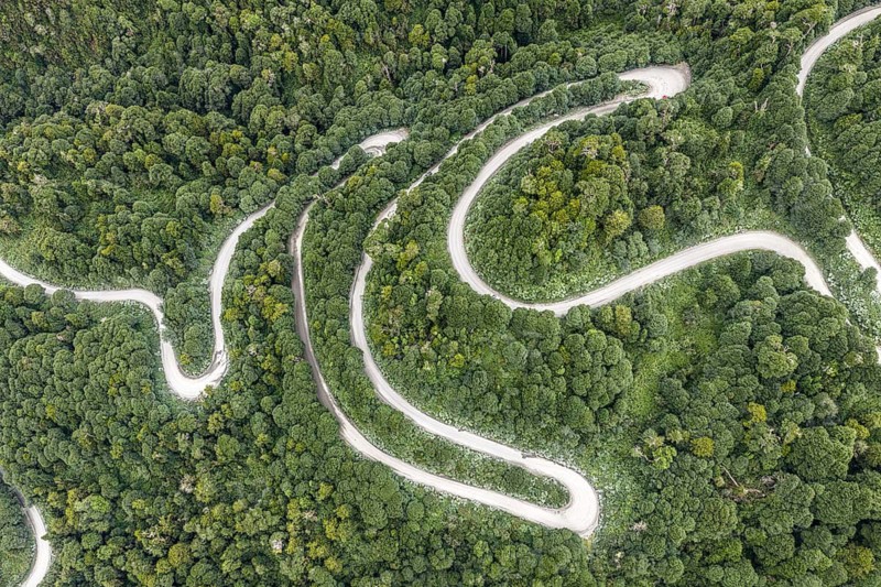 Aerial view of a winding road (Carretera Austral) through dense forest, south of Puyuhuapi, Aysén Region, Chile
