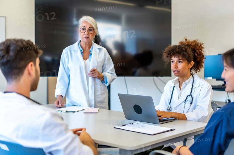 Doctors and medical professionals collaborating, sharing expertise, and analyzing patient information during a productive meeting in a modern hospital setting