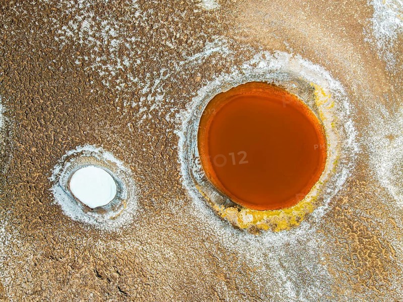 Top view, the Salar de Antofalla in Catamarca, Argentina, showcases vibrant salt pools surrounded by richly textured grounds, captured by drone