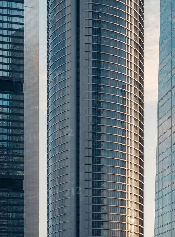 A close-up view of sleek, modern skyscrapers in downtown. The glass and steel structures reflect the dynamic urban environment and the essence of commuting in a bustling city