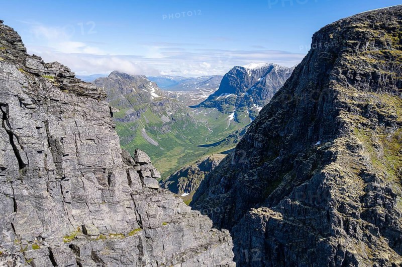 View between rocks at the summit of Innerdalstårnet on Innerdalen high valley, Trollheimen Mountain Area, Sunndal, Møre og Romsda, Vestlandet, Norway
