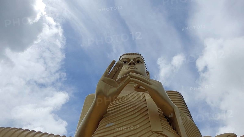 Impressive Buddha sculpture against a cloudy sky, Dambulla, Sri Lanka