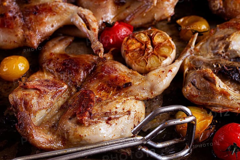 Grilled quail meat, on a platter, tobacco, in the oven, with spices, homemade, without people