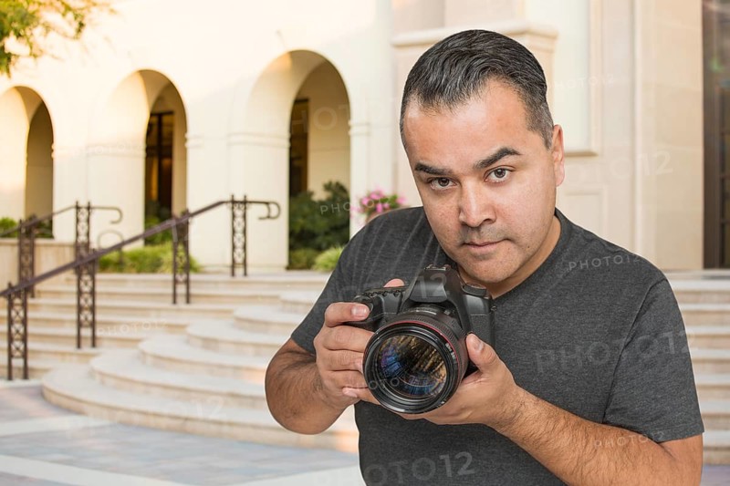 Hispanic Young Male Photographer With DSLR Camera Outdoors