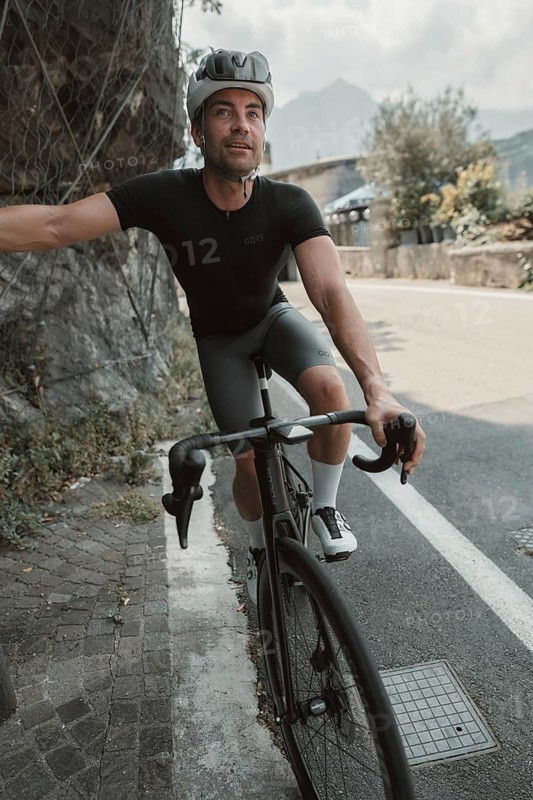 Young man riding a racing bike on Lake Garda. Sunny weather and dolce vita