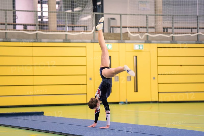 Gymnast doing handstands in a sports hall with yellow, black accents, gymnastics, Calw, Germany