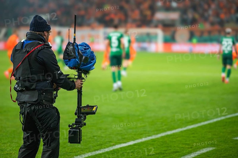 Cameraman behind playing field during soccer match.