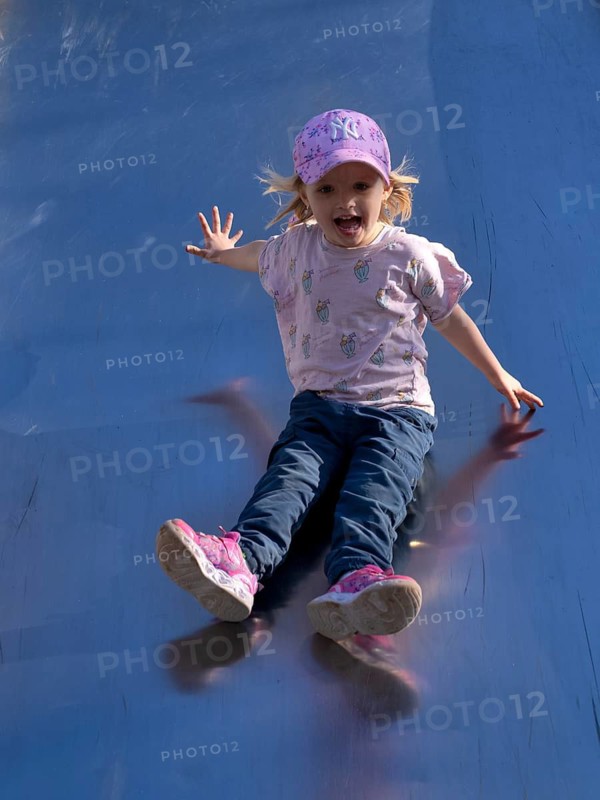 Little girl, 3 years, blonde, baseball cap, logo NYY New York Yankees, slides on slide, playground, Stuttgart, Baden-Württemberg, Germany
