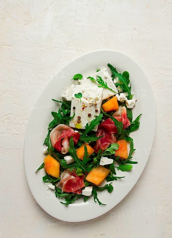 Salad, melon with prosciutto, arugula, and cheese, summer salad, vegetarian, homemade, no people
