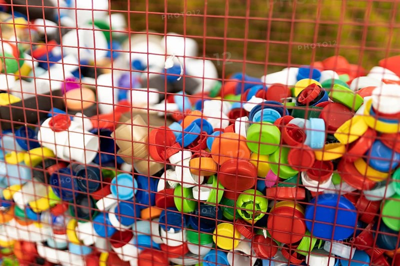 A vibrant assortment of plastic bottle caps collected in a basket, emphasizing the importance of recycling to reduce plastic waste