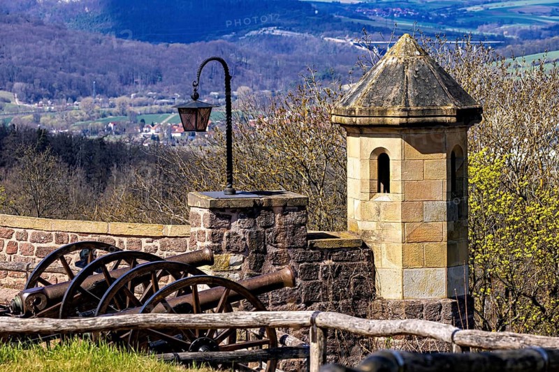 Historical scene with old cannons, a stone lantern and a fortress wall in front of a forest hill, The cannons on the Wartburg entrenchment near Eisenach in Thuringia