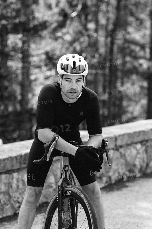 Road bike rider in spring in the Allgäu against the picturesque backdrop of the Alps, Bavaria, Germany