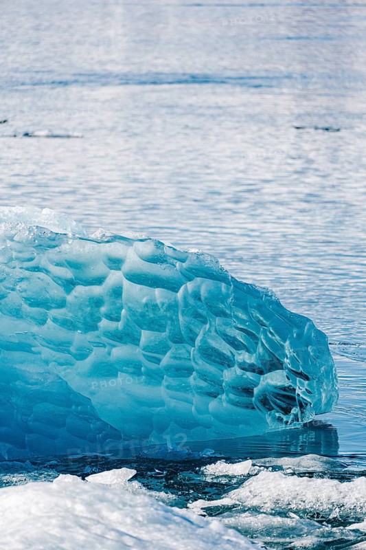 Close-up of vibrant blue ice formations at Diamond Beach, Iceland. The intricate textures and reflections create a stunning natural masterpiece in this serene landscape
