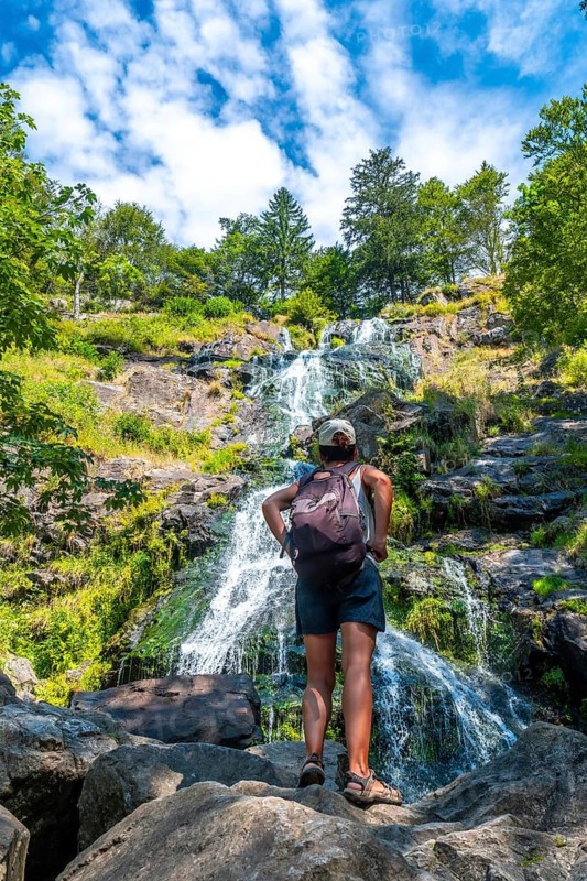 A hiker in summer at the Todtnau waterfall in the Black Forest in Germany